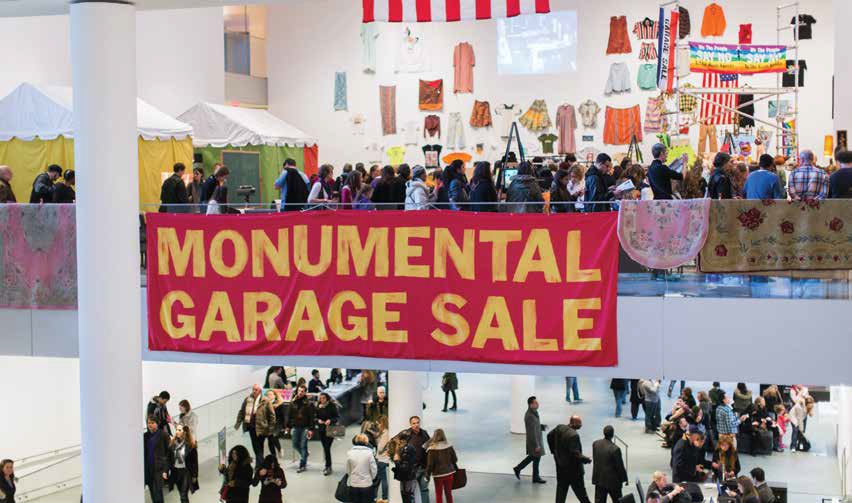 The Monumental Garage Sale at the Museum of Modern Art with a line of people mulling around and several carpets displayed over a glass railing.