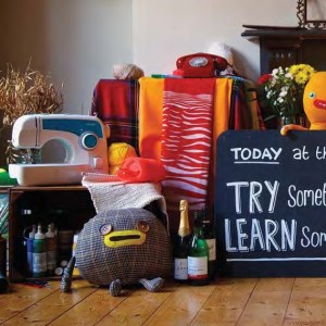 A group of crafting items such as a sewing machine, stuffed toys, a chalk board and other accouterments.