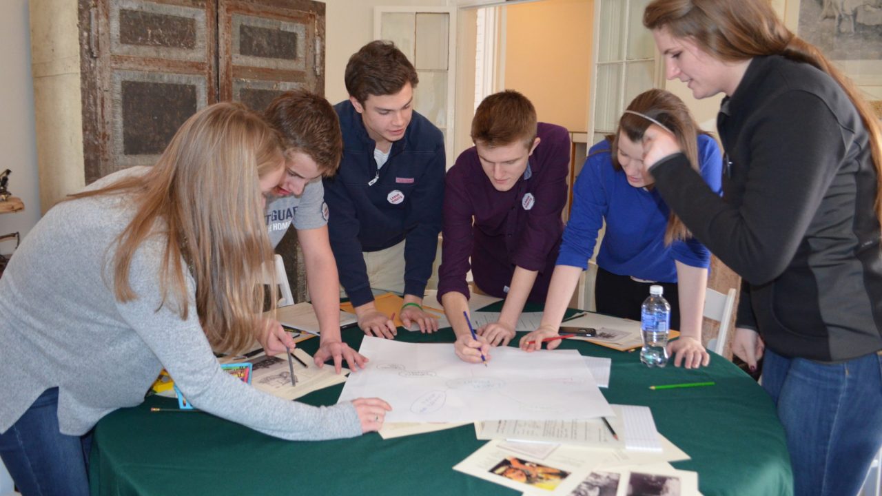 A group of teens around a table playing an Advocacy Game