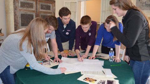 A group of teens around a table playing an Advocacy Game