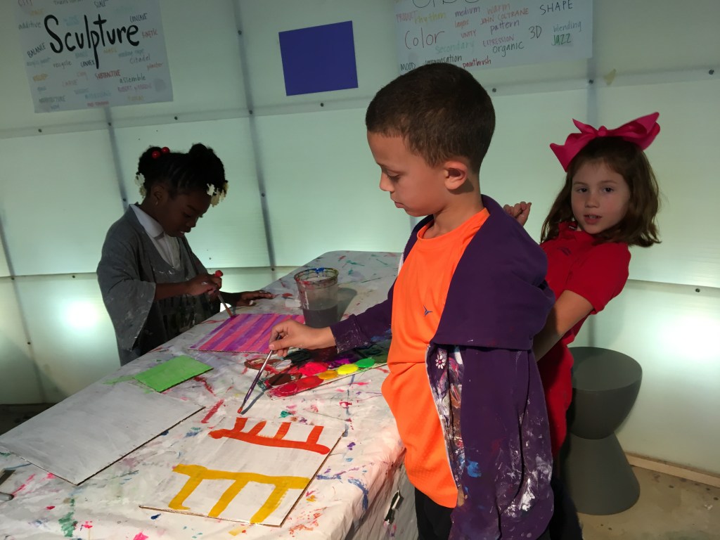 Three students paint abstract paintings