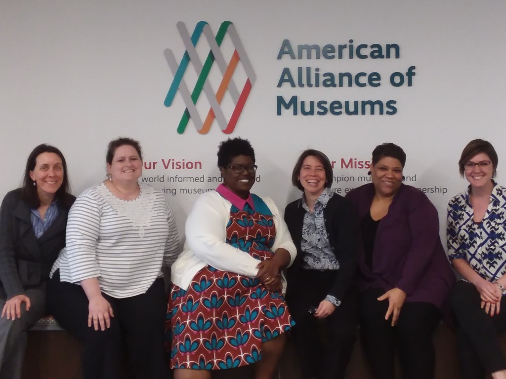 Image of six women sitting in front of the American Alliance of Museums logo