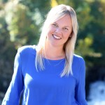 Image of woman standing outside with bright blue shirt and long blond hair