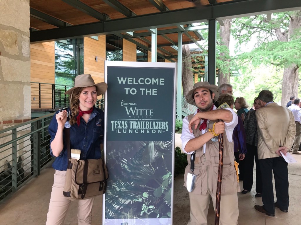 A female and a male staff member pose alongside a sign for Texas Trailblazers