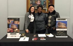 Three people standing at a table with pamphlets