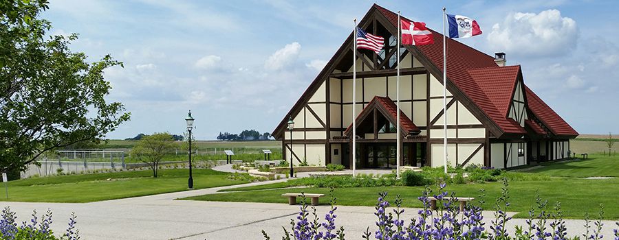 Image of A-frame building with flags in front.