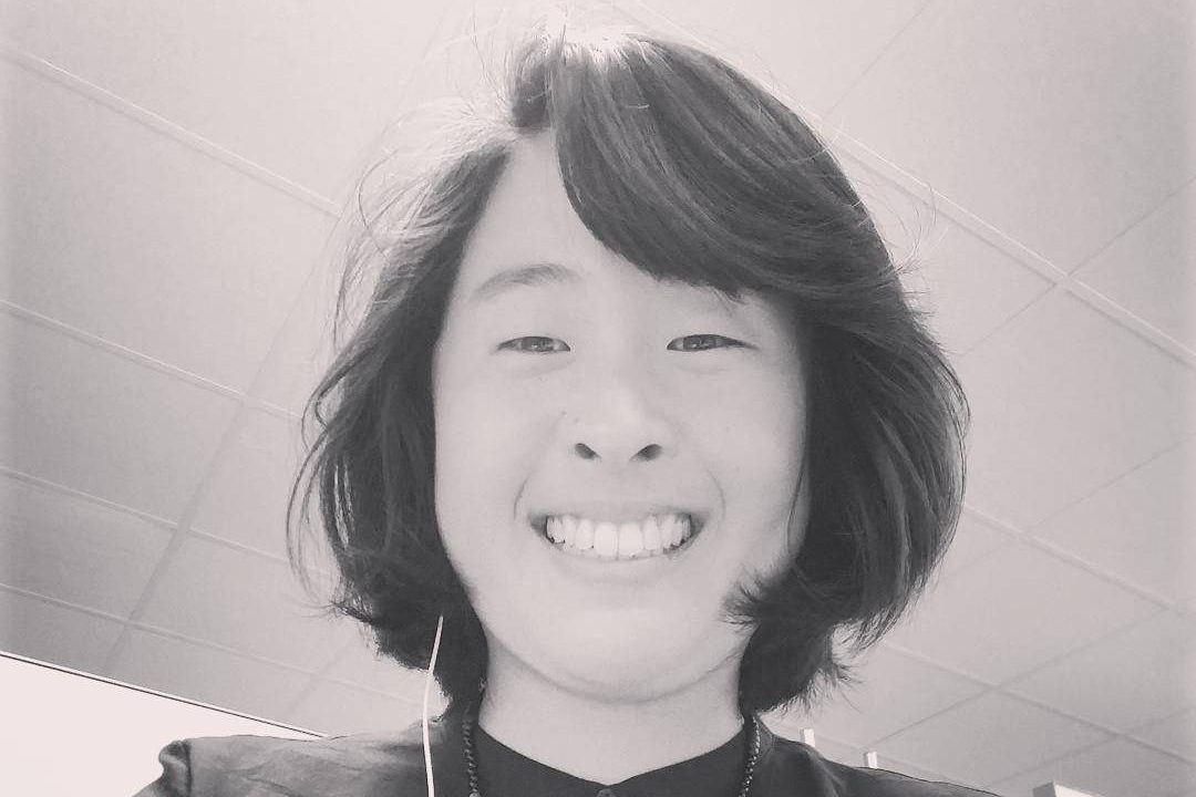 Image of Asian woman looking down into the camera