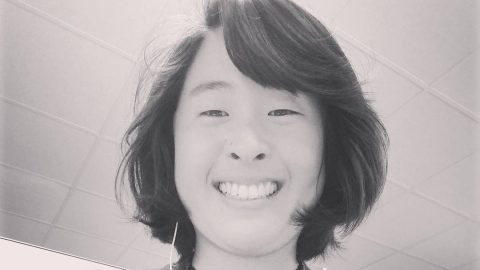 Image of Asian woman looking down into the camera