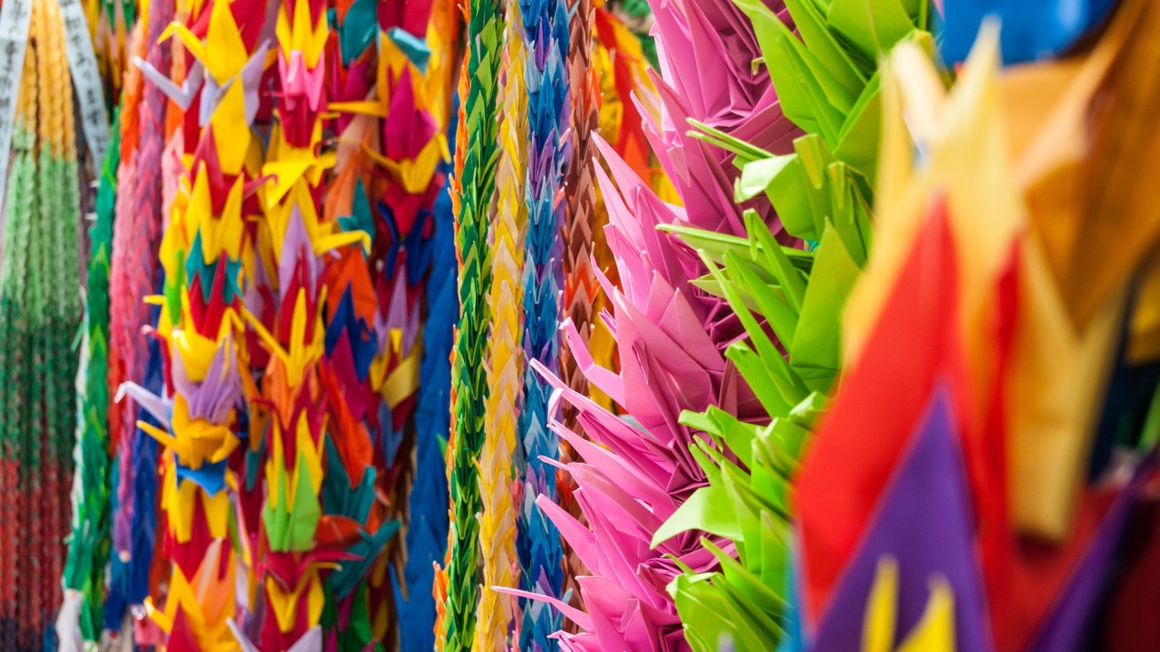 A closeup of brightly color peace crane hanging from garland