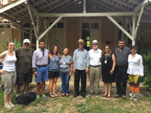 10 people stand in front of a structure smiling