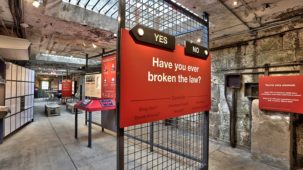 Image of the exhbition with a closeup of one of the labels saying "Have you ever broken the law?"