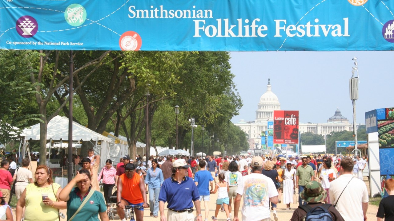 Image of the National Mall with the Capitol building in the backgorund and a large group of people walking toward and away from the camera