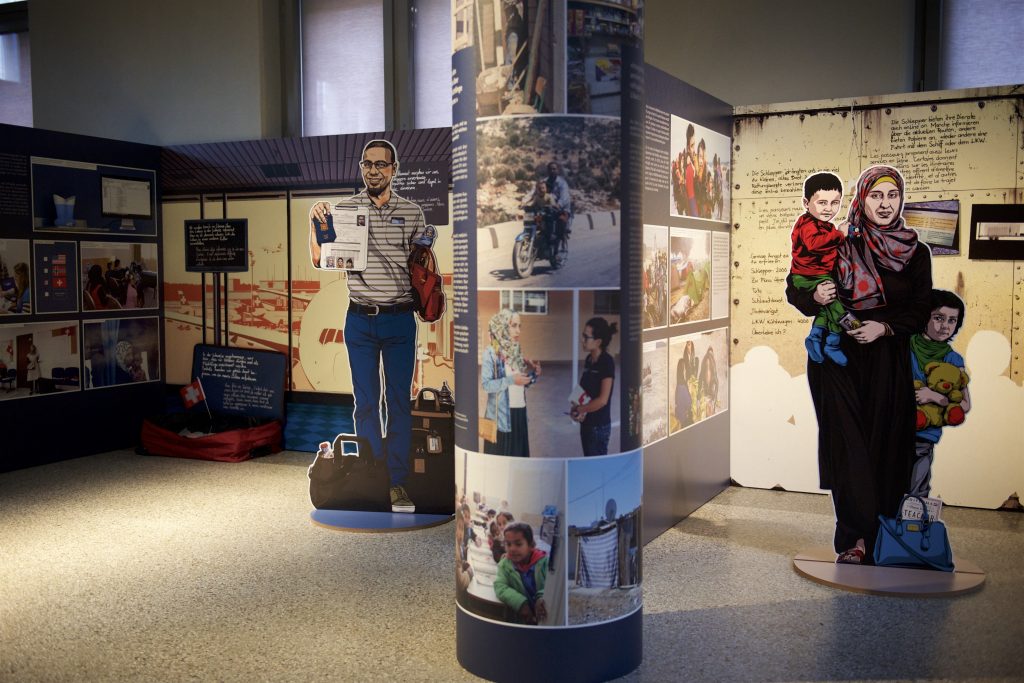Image of an exhibit with two figures shown standing with children