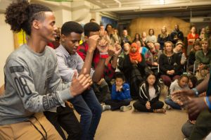 A group of young men dance in front of a crowd of people