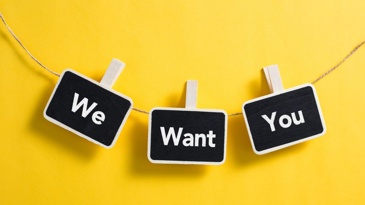 small blackboards hanging on a line spelling out "We Want You"