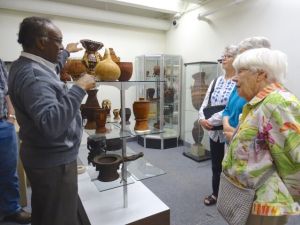 A man explains artifacts to ta group of three women in the museum