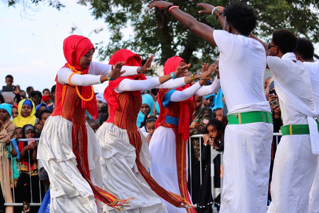 A group of women dressed in traditional Somali garb dance at a festival