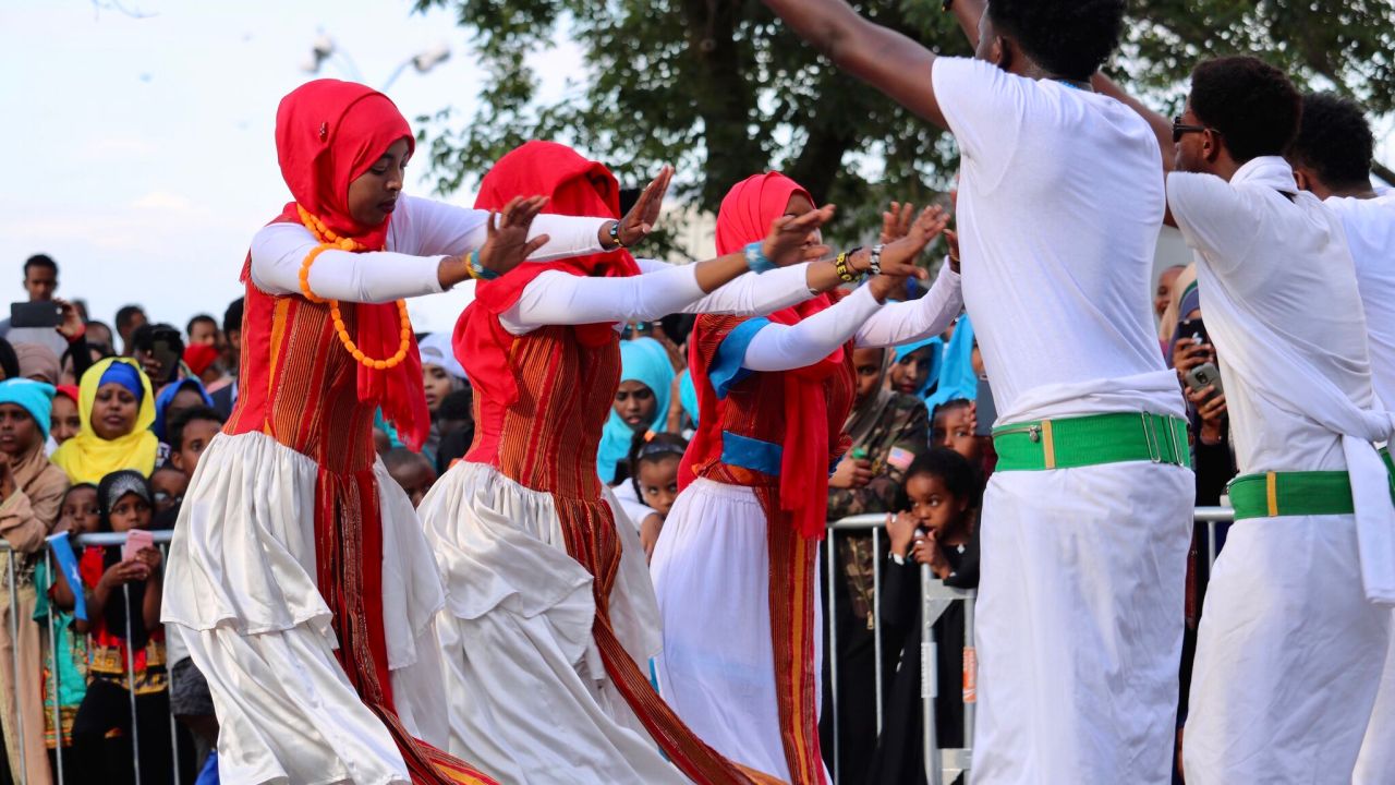 A group of women dressed in traditional Somali garb dance at a festival