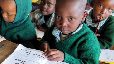 A group of children sit in a classroom