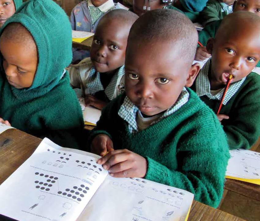 A group of children sit in a classroom