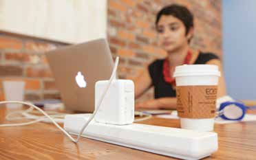 A woman sits with her computer and a cup of coffee in what looks like a coffeehouse. A man sits on a couch with his laptop in a place called the Cove.