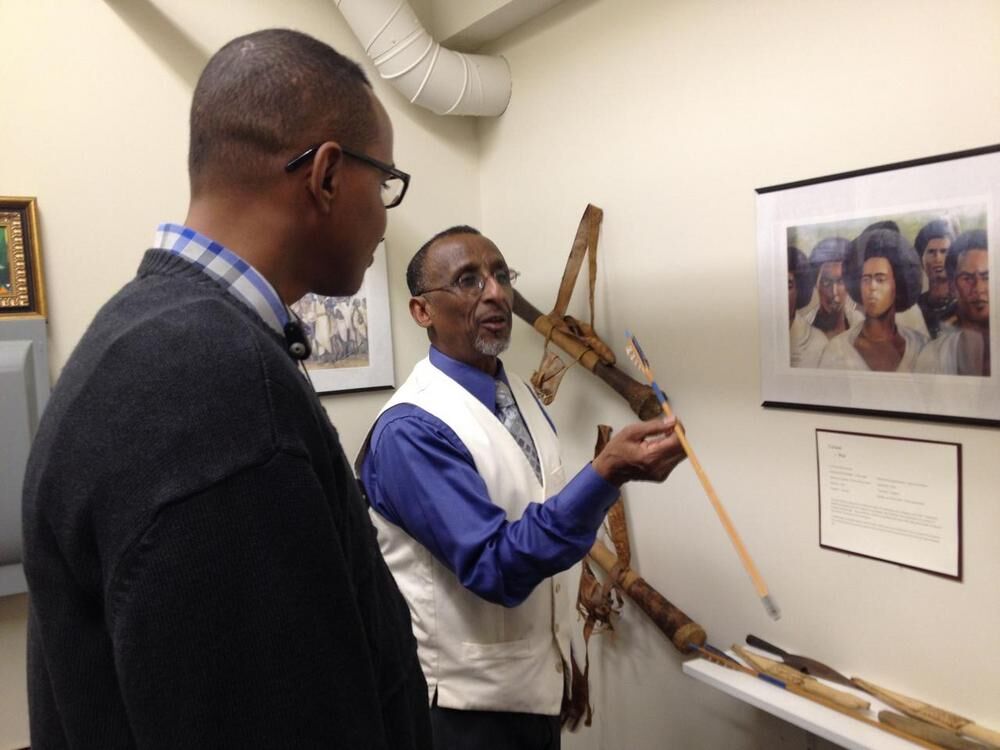 Two men examine an artifact in the museum