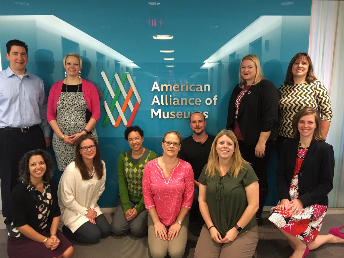 A group of 11 people from EdCom posing in front of the AAM offices