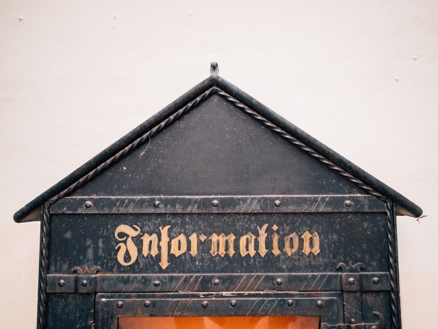Image of an old information sign with a triangle at the top.
