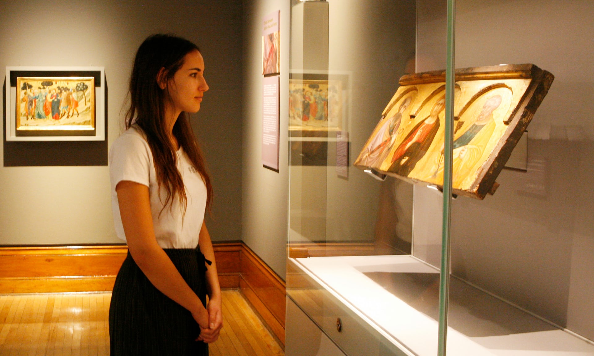 Young woman looking at a an altarpiece painting
