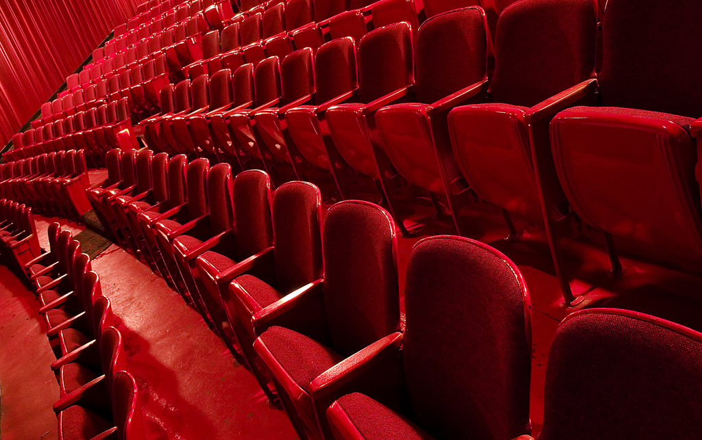 Red theatre seats in parallel rows fading into the distance