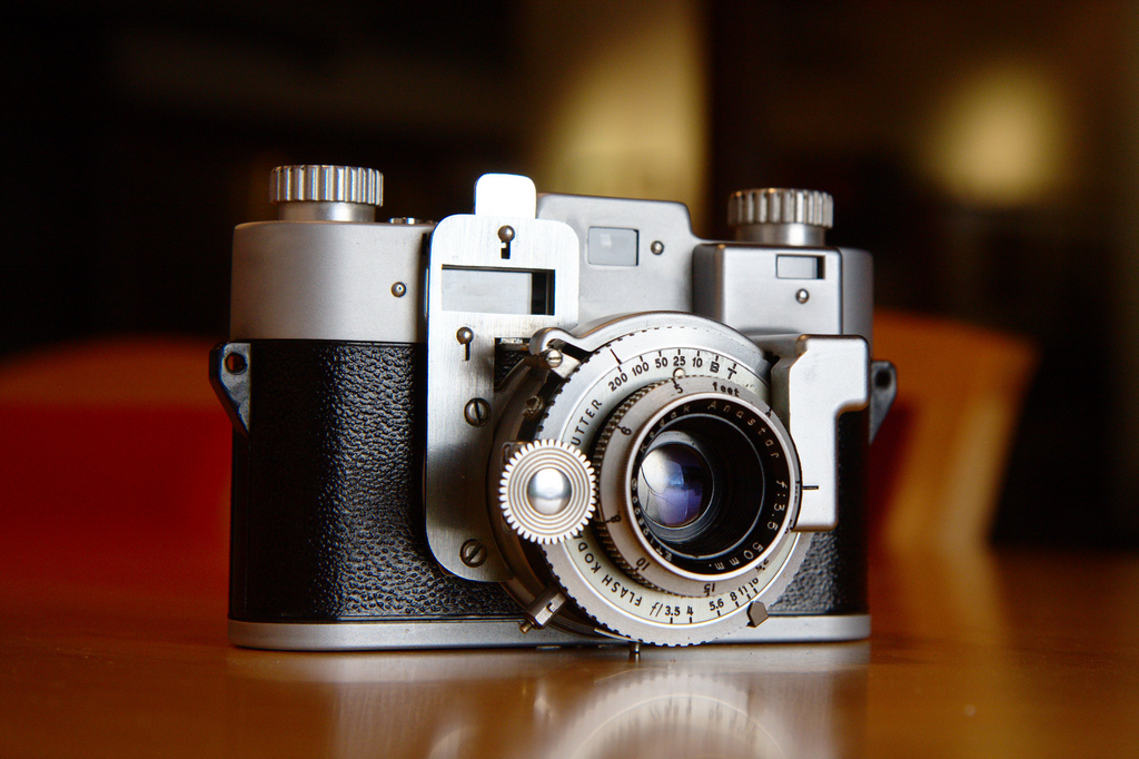 An old camera with mechanical looking lens prominently featured in the image