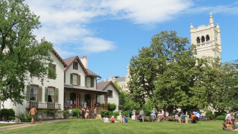 Image of the lawn and house with a group of people milling around.