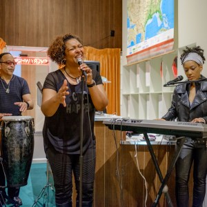 A group of musicians play and sing in the Motel Sessions exhibition.