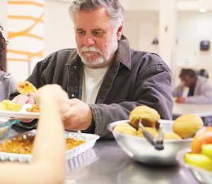 A man stands in line receiving food.