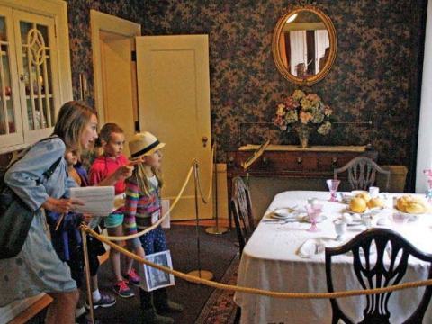 Image of a family of two children viewing the dining room at the Pittock Mansion.
