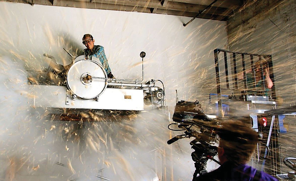 View of a person working up high on a wall and sparks flying everywhere.