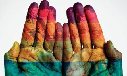 Image of two open hands facing the camera with various colors painted all over them.