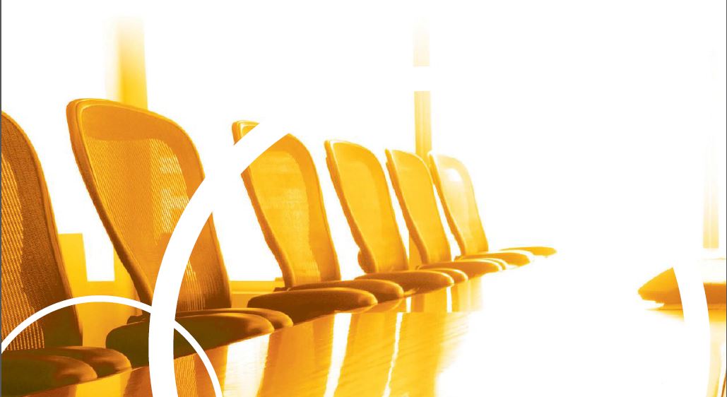 An orange colored board table with chairs.