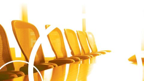 An orange colored board table with chairs.