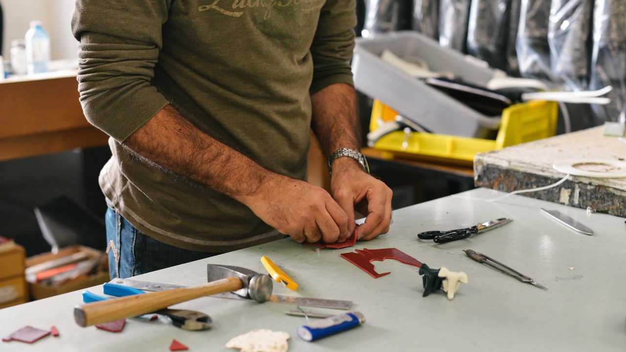 Closeup image of a man working on a small piece of plastic.