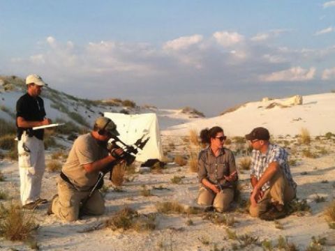 Image of four people in a sandy area. Two of the people are on camera. 