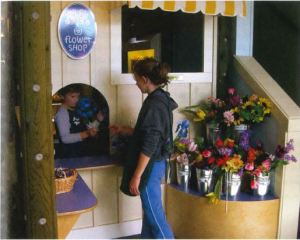 A young child "works" at a flower shop in a Children's Museum