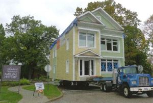 Image of a house on a flatbed truck. 