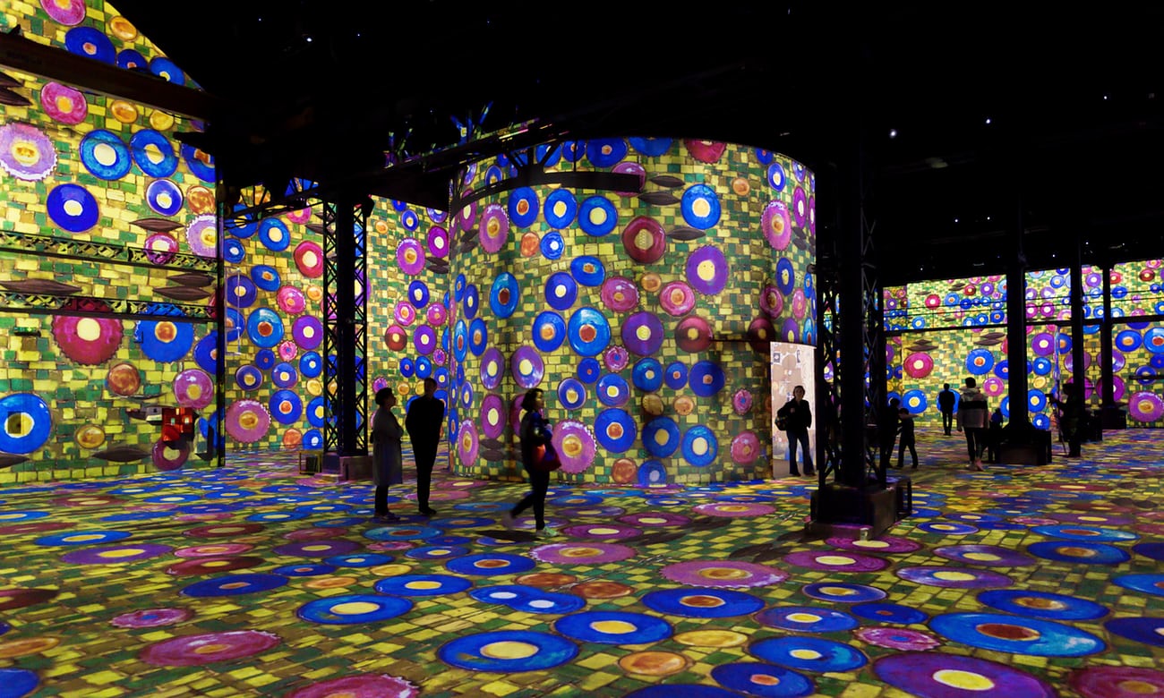 Visitors in the La Halle space at Atelier des Lumières