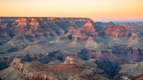 Wide image of the Grand Canyon with lots of oranges and reds.