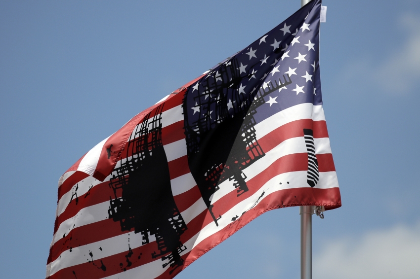 An image of an American flag with black geometric patterns on it.