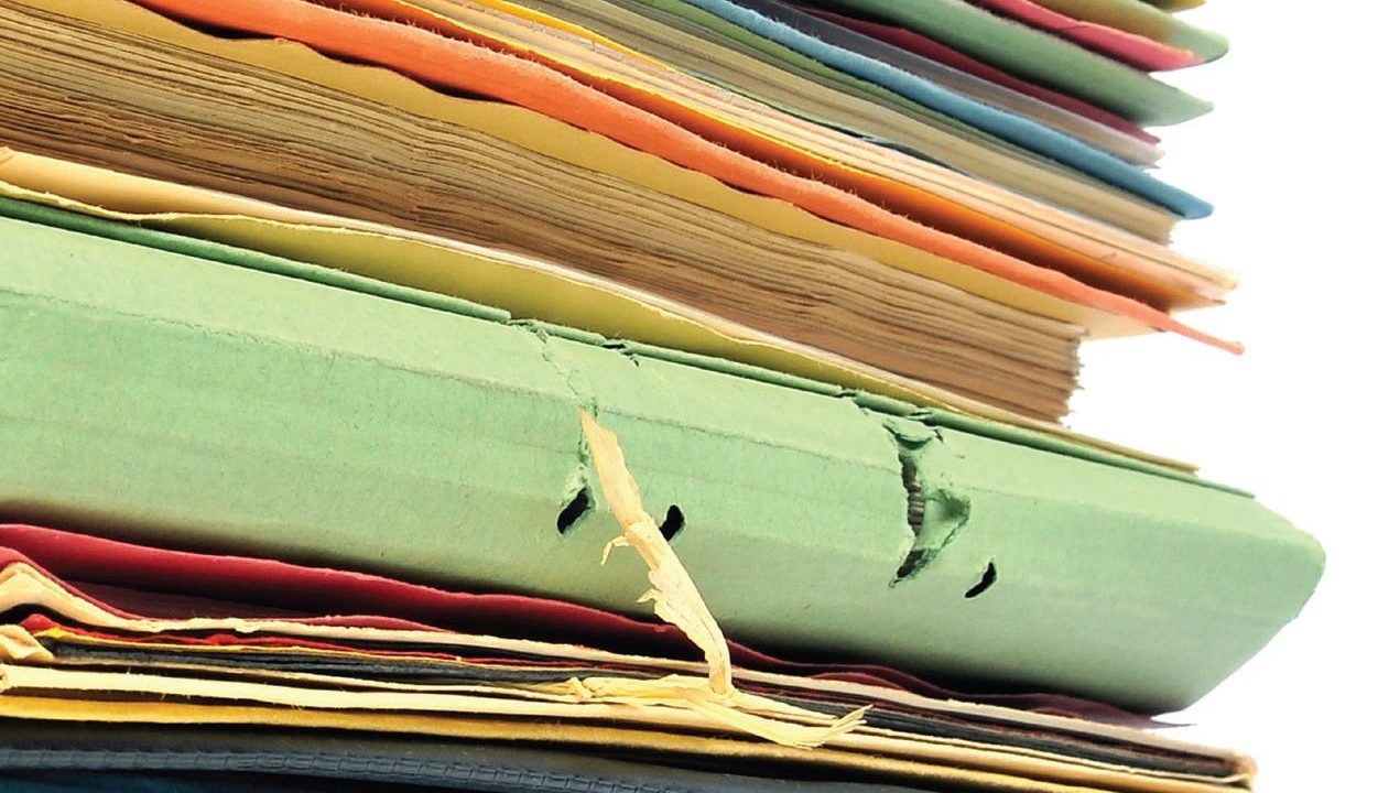 View of a stack of pagers and folders in varying colors.