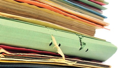 View of a stack of pagers and folders in varying colors.