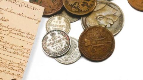 A historical document and a series of coins stacked on top of each other.