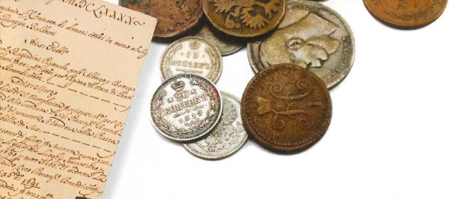 A historical document and a series of coins stacked on top of each other.
